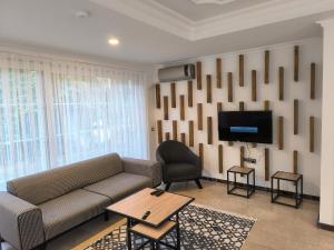 a living room with a couch and a tv at Amazonica MAGİC DREAM in Kemer