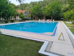 a swimming pool with a triangle in the grass at Amazonica MAGİC DREAM in Kemer