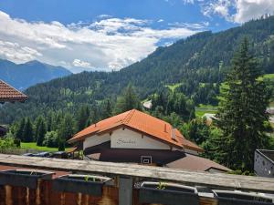 a building with an orange roof with mountains in the background at Elgi Apart in Serfaus