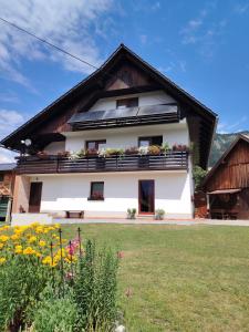 een gebouw met bloemen ervoor bij Apartma in soba pri Bregarju in Bohinj