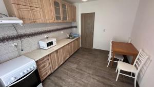 a small kitchen with a microwave and a table at Cazare Herculane in Băile Herculane