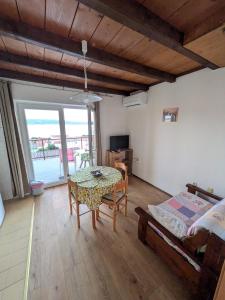 a living room with a table and a bed at Apartmani Lili in Crikvenica