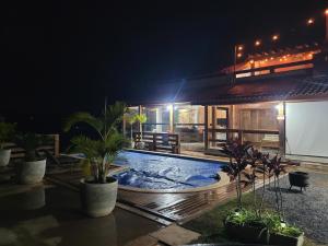 a house with a swimming pool at night at Chácara La Belle de Jour in Piedade +6 photos