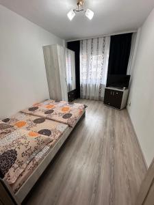 a bedroom with a bed and a wooden floor at Cazare Herculane in Băile Herculane