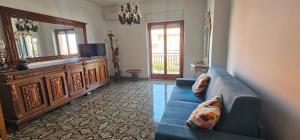 a living room with a blue couch and a mirror at Miramare72 in Crotone