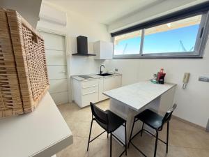 a kitchen with a table and chairs and a window at Sisters 'Home - Appartamenti di Charme nel Cuore di Milazzo in Milazzo
