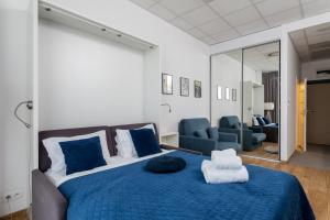 a bedroom with a blue bed and blue chairs at ALE Jerozolimskie Varsovia Apartments in Warsaw