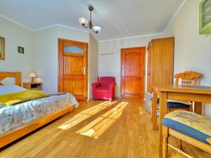 a bedroom with a bed and a red chair at Willa Tradycja in Łeba