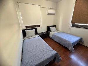 a room with two beds and a window at Lama's Residence in Nicosia