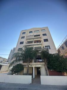 a tall building with a palm tree in front of it at Lama's Residence in Nicosia