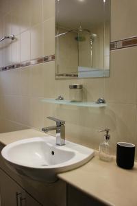 a bathroom with a white sink and a mirror at Lama's Residence in Nicosia
