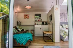a tiny house with a kitchen and a living room at Reflections, Netherby, a micro cabin with hot tub in a rural setting in Longtown