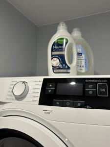 una lavadora con una botella de detergente para ropa en Colorful Apartments G, en Riga