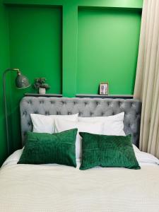 1 dormitorio verde con 1 cama con paredes verdes en Colorful Apartments G, en Riga
