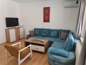 ザイェチャルにあるApartman Meridianの青いソファとテーブルのあるリビングルーム