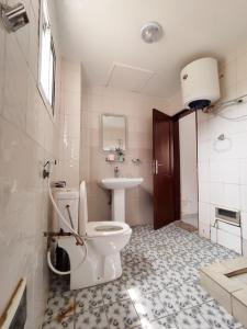 a bathroom with a toilet and a sink at Appartement meublé spacieux 2 chambres salon Yassa in Douala