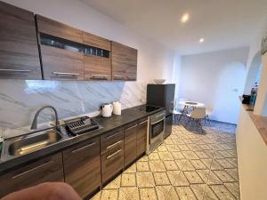 a kitchen with wooden cabinets and a sink and a table at Pensjonat Eden Apartament 4 in Borne Sulinowo