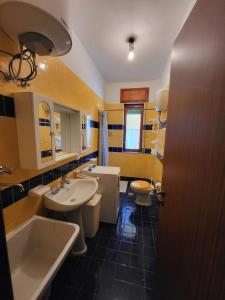 a bathroom with two sinks and a tub and a toilet at Il Parco Passolara in Acciaroli