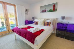 a bedroom with a large bed with towels on it at House 28 in Looe +22 photos