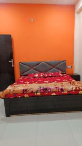 FaizābādArya guest house的橙色墙壁间的一张床位