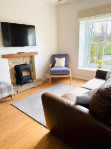 een woonkamer met een bank en een open haard bij The Hayloft Cottage in Whitby