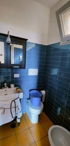 a blue tiled bathroom with a toilet and a sink at H2o casa vacanza in Ascea