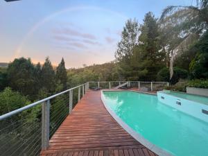 a wooden bridge over a swimming pool on a house at RIVERLEA RETREAT MUDGEE - Private, Outdoor Bath, Pool, Tranquility in Apple Tree Flat