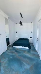 a white bedroom with a bed and a blue floor at Bristol in Kvariati