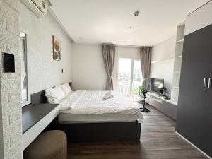a bedroom with a bed and a tv in it at Modern Garden Apt by Dragon bridge in Da Nang