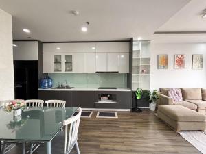 a kitchen and living room with a table and a couch at Modern Garden Apt by Dragon bridge in Da Nang