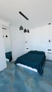 a white bedroom with a bed and two lights at Bristol in Kvariati