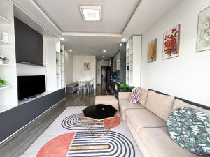 a living room with a couch and a table at Modern Garden Apt by Dragon bridge in Da Nang
