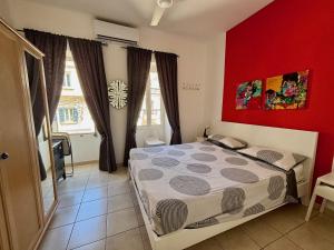 a bedroom with a red wall and a bed at Simons Apartments minutes away from Balluta Bay and St Julians in Sliema