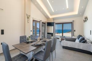 a dining room with a table and a couch at Beachfront Villa Fteri in Kefalonia