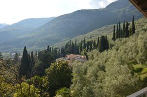 a house in the middle of a valley with trees at 1Dest - Arco Climbing in Arco