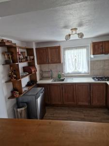 a kitchen with wooden cabinets and a window and a sink at Casa Chindea Lacu Rosu in Lacu Rosu +31 photos