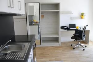 eine Küche mit einem Schreibtisch und einem Stuhl in einem Zimmer in der Unterkunft Zimmer in Wohngemeinschaft im Land of Living Regensburg in Kelheim + 4 Fotos