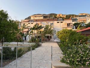 a building with a fence in front of a garden at White Marine Hotel in Qeparo