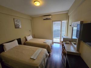 a hotel room with two beds and a flat screen tv at Hotel Venec in Debar