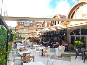 an outdoor patio with tables and chairs in a restaurant at Hotel Venec in Debar