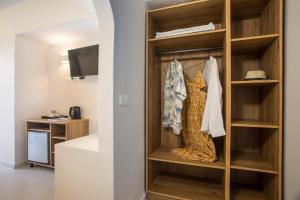 a room with a book shelf and a tv at Nikos BnB in Faliraki