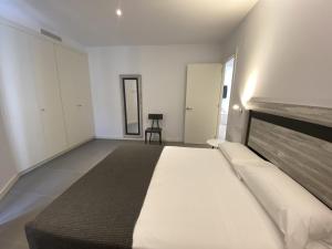 a bedroom with a large bed and a chair at Can Calo 2B in Castelló d'Empúries