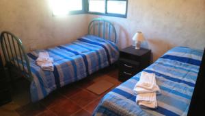 Dos camas en una habitación con toallas. en CABAÑAS LDM en San Isidro