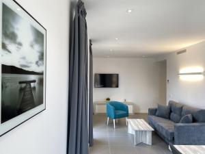 a living room with a blue couch and a table at can Calo 3B in Castelló d'Empúries