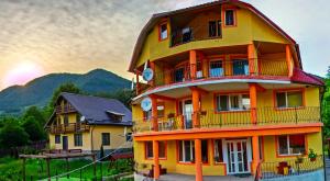 un edificio amarillo con balcones en un lateral en Casa Potcoava, en Lepşa