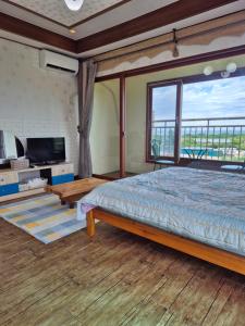 a bedroom with a bed and a large window at Jun House in Jeju