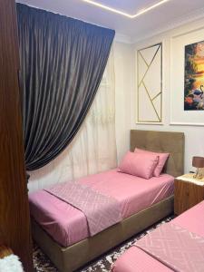 a bedroom with two beds and a window with purple curtains at بورتو مطروح - Porto Matrouh in Marsa Matruh