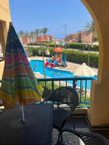 an umbrella and chairs and a swimming pool at بورتو مطروح - Porto Matrouh in Marsa Matruh +3 photos