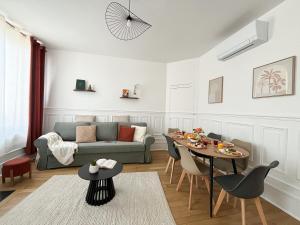a living room with a couch and a table at Le Charmant, 2 chambres, Parking in Pagny-sur-Moselle