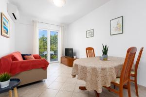 a living room with a table and a couch at Apartments Bogović in Malinska